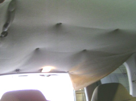 Worn out headliner using thumb tacs to hold it up (not recommended)